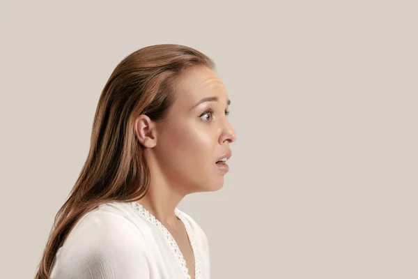 Hermosa mujer mirando sorprendido aislado en gris —  Fotos de Stock