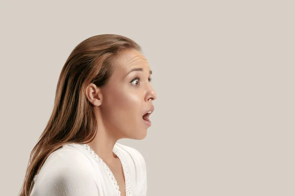 Hermosa mujer mirando sorprendido aislado en gris —  Fotos de Stock