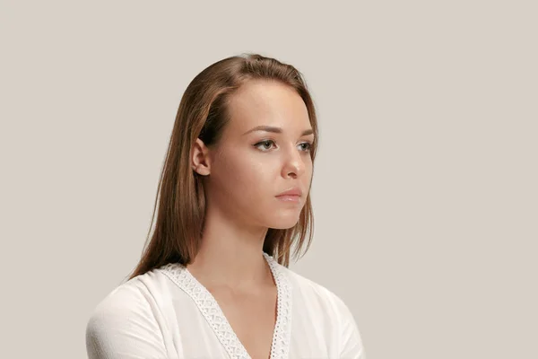 The serious business woman standing and looking at camera against gray background. — Stock Photo, Image