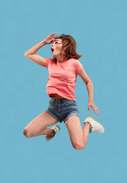 Liberdade em movimento. Mulher muito jovem pulando contra fundo azul — Fotografia de Stock