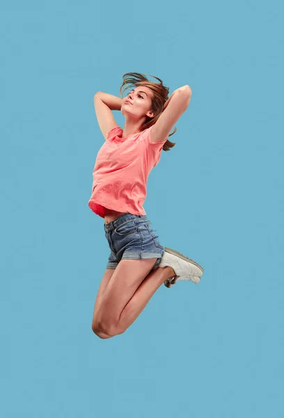 이동의 자유입니다. 파란색 배경 점프 예쁜 젊은 여자 — 스톡 사진