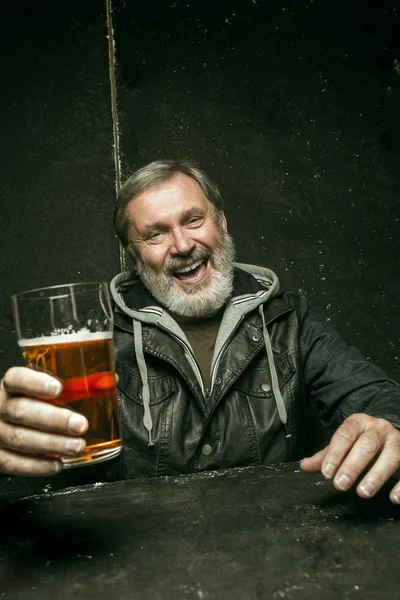 Sonriente barbudo macho bebiendo cerveza en el pub — Foto de Stock