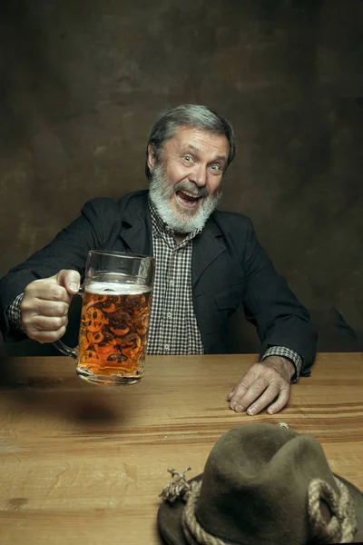 Sonriente barbudo macho bebiendo cerveza en el pub — Foto de Stock