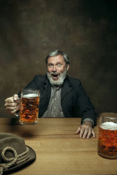Smiling bearded male drinking beer in pub — Stock Photo, Image
