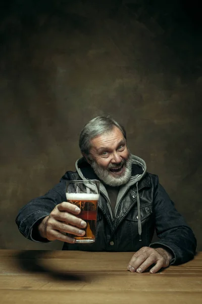 Smiling bearded male drinking beer in pub — Stock Photo, Image