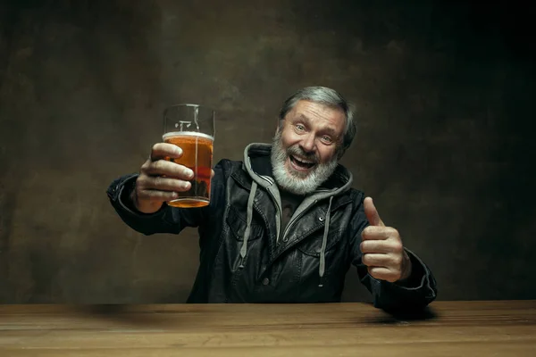 Smiling bearded male drinking beer in pub — Stock Photo, Image