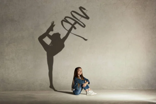 Baby girl dreaming about gymnast profession. Childhood concept.