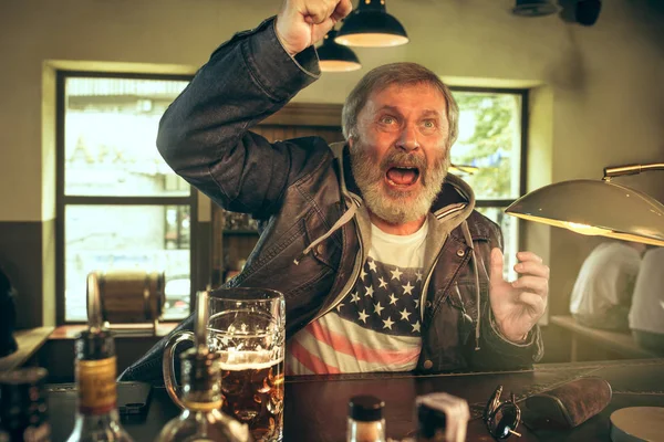 Старший бородатий чоловік п'є пиво в пабі — стокове фото