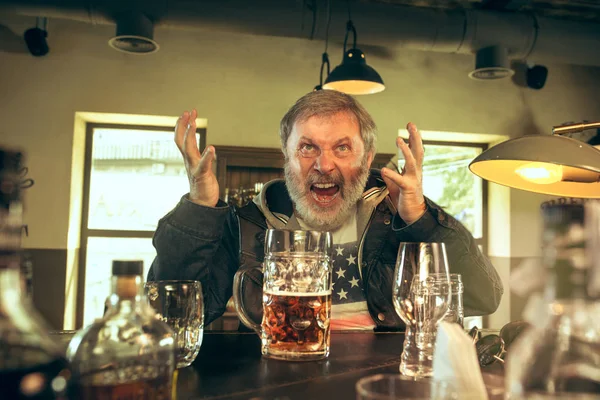 De senior gebaarde mannelijke drinken bier in de kroeg — Stockfoto