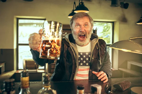 El hombre barbudo mayor bebiendo cerveza en el pub —  Fotos de Stock
