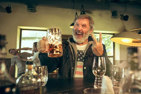 Старший бородатий чоловік п'є пиво в пабі — стокове фото