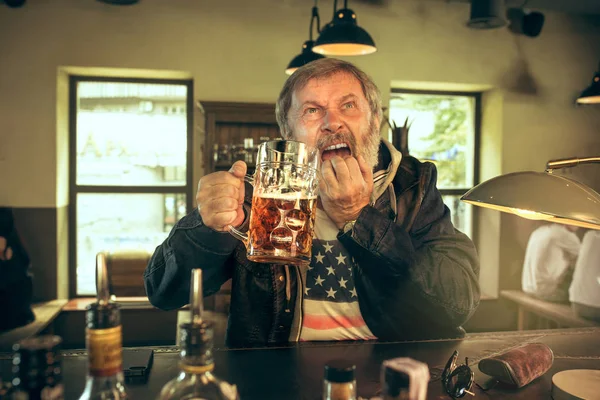 Der traurige bärtige Senior trinkt Bier in der Kneipe — Stockfoto