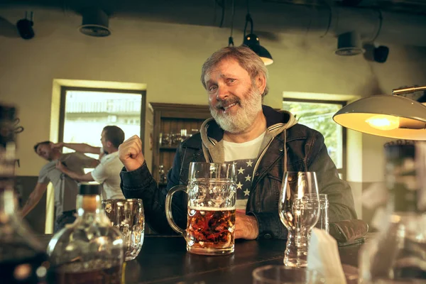 El hombre barbudo mayor bebiendo cerveza en el pub — Foto de Stock
