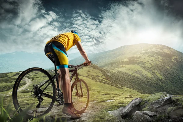 Ο νεαρός άνθρωπος ταιριάζει στο κράνος κατακτώντας βουνά σε ένα ποδήλατο. — Φωτογραφία Αρχείου