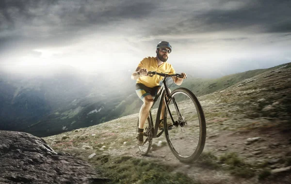 Genç erkekler bir bisiklet dağlardaki fetih kask içinde yerleştirmek. — Stok fotoğraf