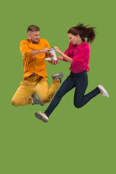 Schönes junges Paar springt mit Megafon isoliert über grünem Hintergrund — Stockfoto