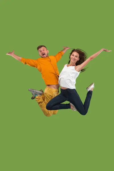 Libertad de movimiento. Bastante joven pareja saltando sobre fondo verde —  Fotos de Stock