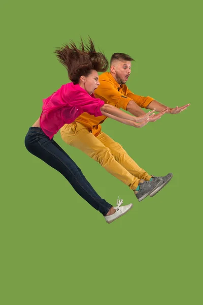 Svoboda v pohybu. Krásná mladá dvojice skákání proti zeleným pozadím — Stock fotografie