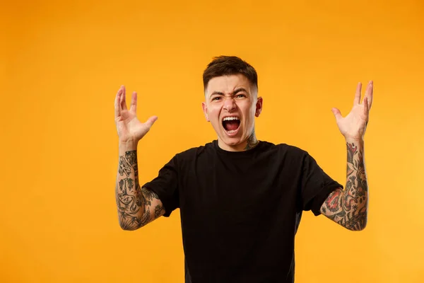 O jovem homem irritado emocional gritando no fundo do estúdio — Fotografia de Stock