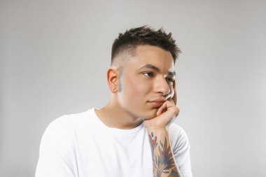 Güzel sıkılmış adam sıkılmış gri arka plan üzerinde izole