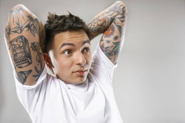 Şaşırmış görünen çekici adam gri izole genç