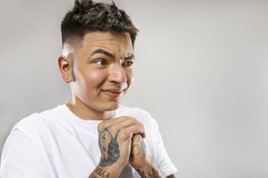 Gri üzerine izole bir şey geçirmeyen tiksinti ifadesi ile genç adam