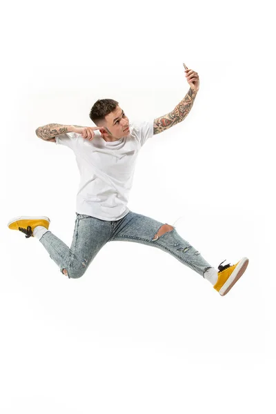 Comprimento total de belo jovem tomando selfie enquanto salta — Fotografia de Stock
