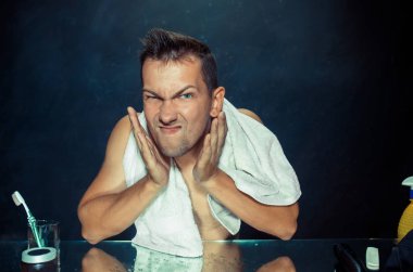 Yatak odası oturma sakalını tırmalamak aynanın önünde genç adam