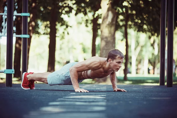 Atleta haciendo ejercicios en el estadio en el parque — Foto de Stock