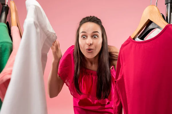 La joven chica bonita mirando vestidos y probarlo mientras elige en la tienda — Foto de Stock