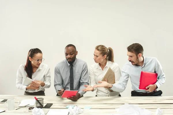 Hombres y mujeres jóvenes sentados en la oficina y trabajando en computadoras portátiles. Concepto de emociones — Foto de Stock