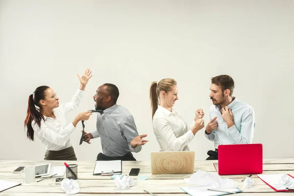 Hombres y mujeres jóvenes sentados en la oficina y trabajando en computadoras portátiles. Concepto de emociones — Foto de Stock