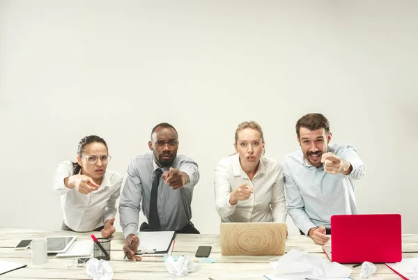 Hombres y mujeres jóvenes sentados en la oficina y trabajando en computadoras portátiles. Concepto de emociones — Foto de Stock