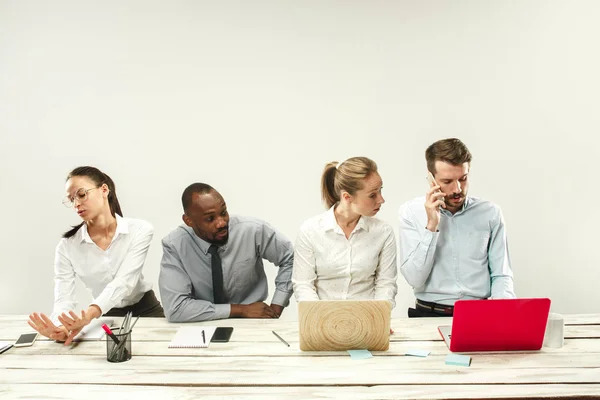 Hombres y mujeres jóvenes sentados en la oficina y trabajando en computadoras portátiles. Concepto de emociones — Foto de Stock