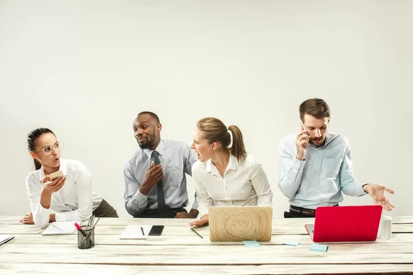 Hombres y mujeres jóvenes sentados en la oficina y trabajando en computadoras portátiles. Concepto de emociones —  Fotos de Stock