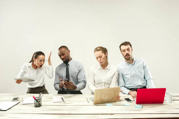 Young men and women sitting at office and working on laptops. Emotions concept