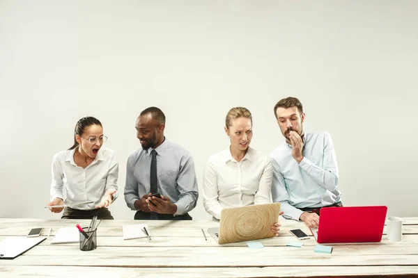 Junge Männer und Frauen sitzen im Büro und arbeiten an Laptops. Emotionen-Konzept — Stockfoto