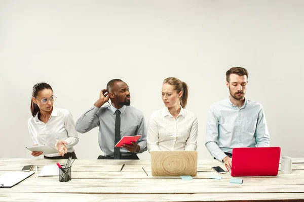 Giovani uomini e donne seduti in ufficio a lavorare su computer portatili. Concetto di emozioni — Foto Stock
