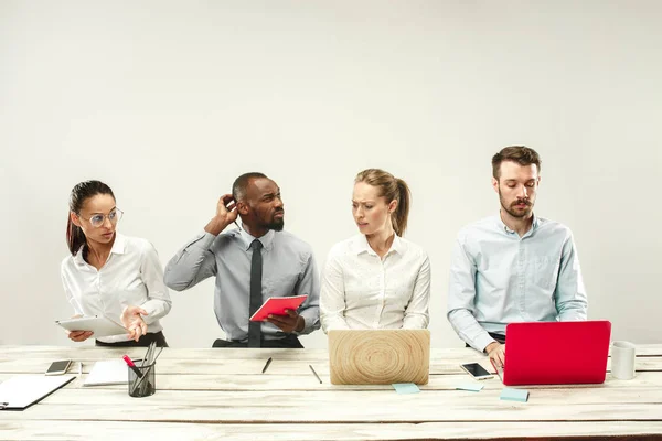 Junge Männer und Frauen sitzen im Büro und arbeiten an Laptops. Emotionen-Konzept — Stockfoto