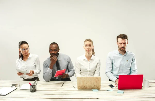 Mladí muži a ženy sedí v kanceláři a pracuje na notebooky. Koncept emoce — Stock fotografie