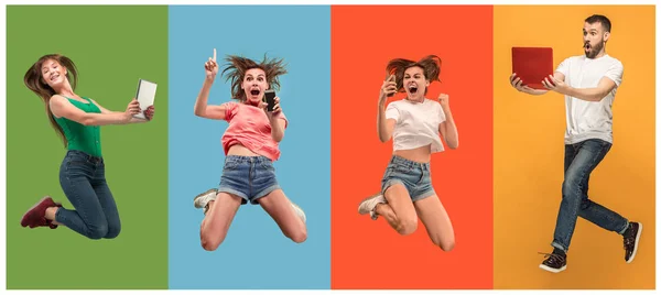 Mutlu genç kadın ve erkek dizüstü bilgisayarlar ve telefon ile atlama — Stok fotoğraf