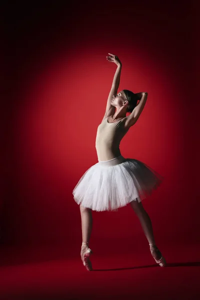 Ballerina. Young graceful female ballet dancer dancing at red studioskill. Beauty of classic ballet. — Stock Photo, Image