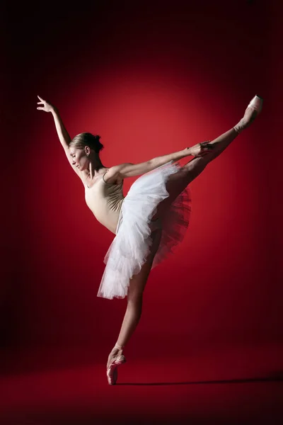 Ballerina. Young graceful female ballet dancer dancing at red studioskill. Beauty of classic ballet. — Stock Photo, Image