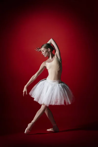 Ballerina. Young graceful female ballet dancer dancing at red studioskill. Beauty of classic ballet. — Stockfoto