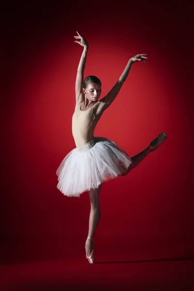 Bailarina. Joven bailarina de ballet femenina elegante bailando en los estudios rojos. Belleza del ballet clásico . — Foto de Stock