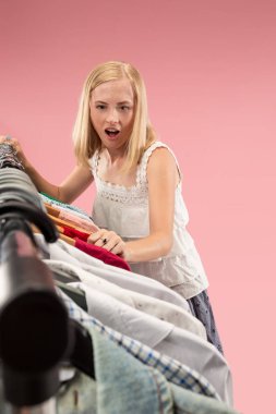 Genç güzel kız elbise seyir ve üzerinde dükkanında seçerken deneyin