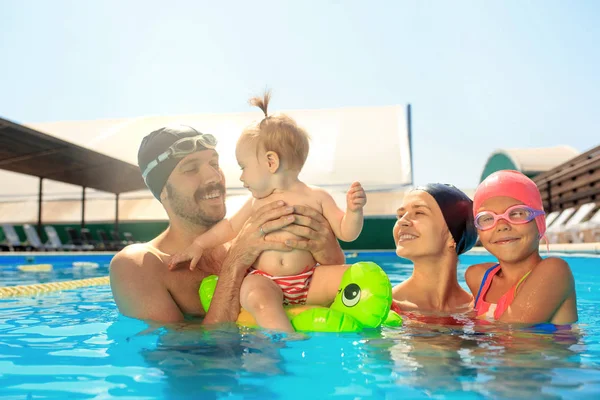 Familia feliz divirtiéndose junto a la piscina —  Fotos de Stock