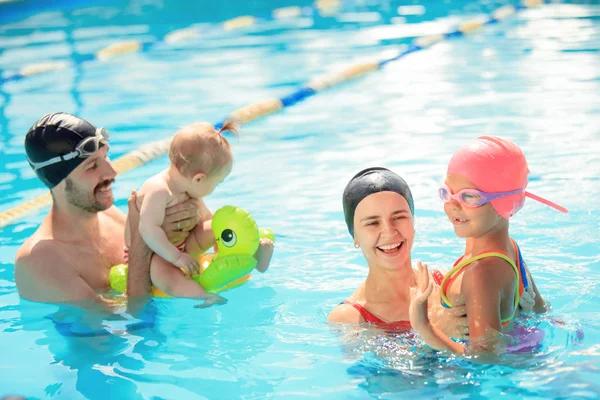 Família feliz se divertindo na piscina — Fotografia de Stock