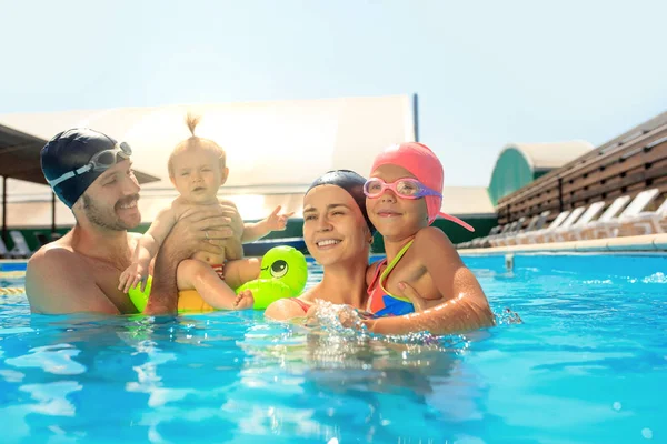 Família feliz se divertindo na piscina — Fotografia de Stock