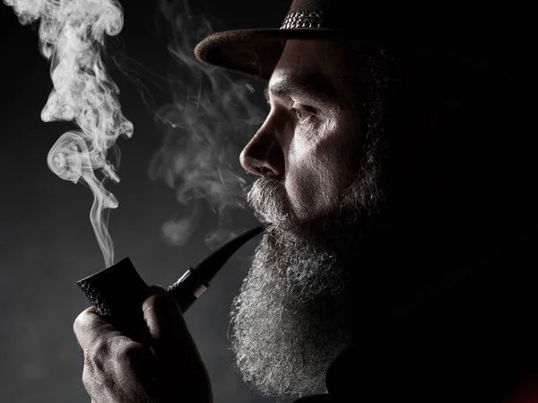 Dramatisches Porträt von Senioren, die Tabakpfeife rauchen — Stockfoto